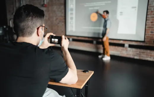 a man taking a picture of a man on a screen