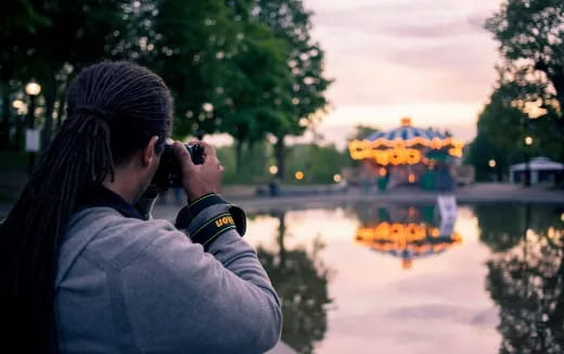 a man taking a picture of a pond