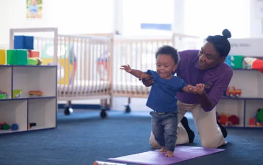 a person and a child playing on a mat in a room