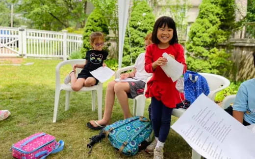 a person and a couple of children sitting in lawn chairs