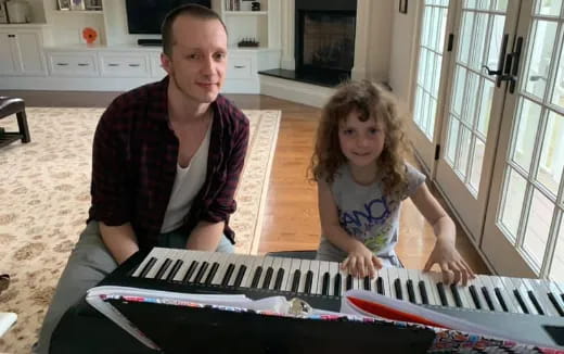 a person and a girl playing a piano