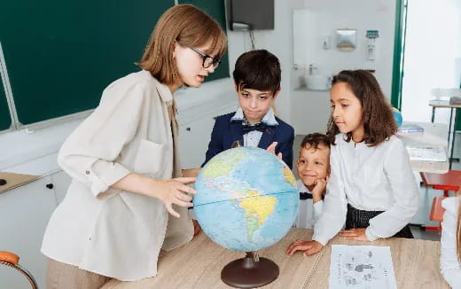 a person and several children looking at a globe