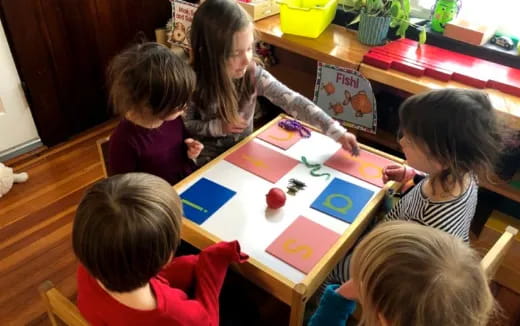 a person and several children sitting at a table