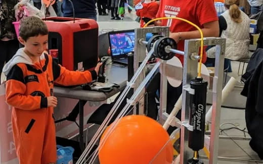 a person in an orange suit working on a machine