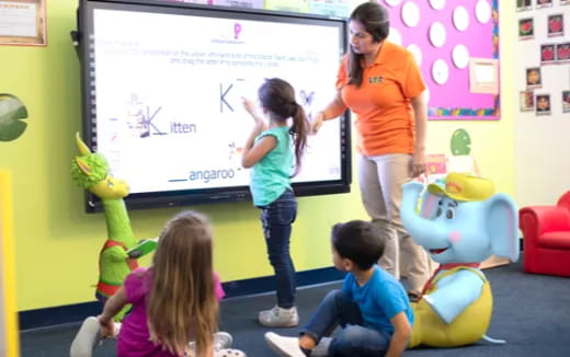 a person teaching children how to play a video game