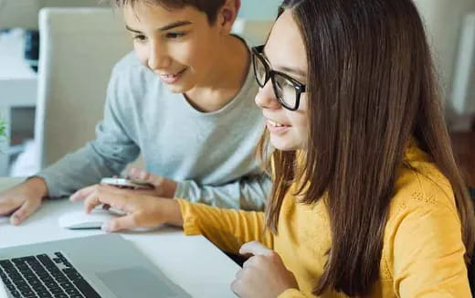 a woman and a man looking at a laptop