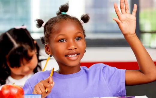 a young girl with a ponytail holding a ball and a finger up