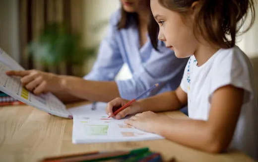 a young girl writing on a book