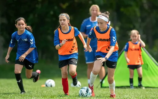 girls playing football on a field