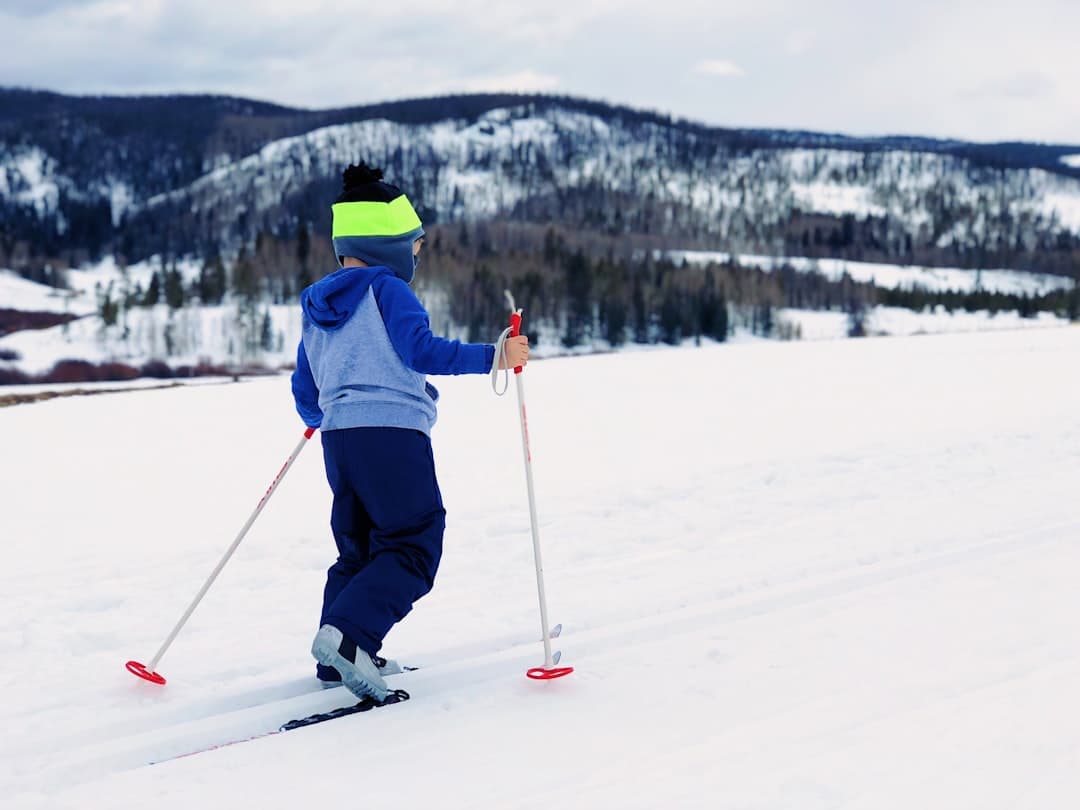 boy in blue and gray hoodie doing snow ski