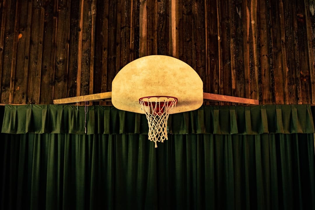 brown and red basketball hoop near green curtains