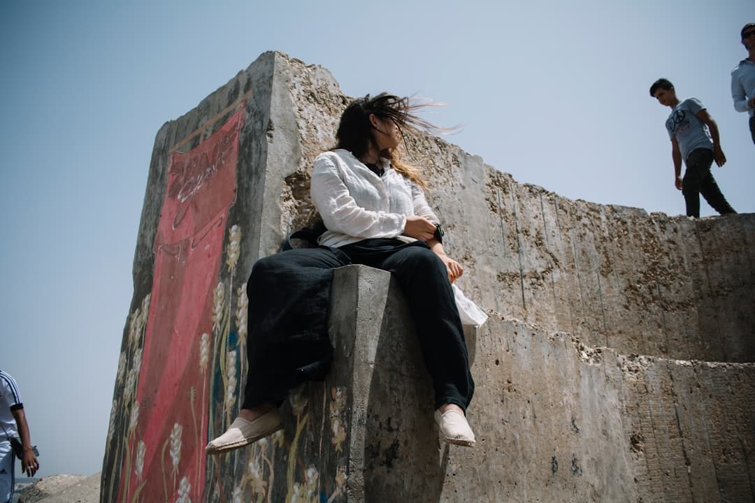 woman sitting on concrete wall