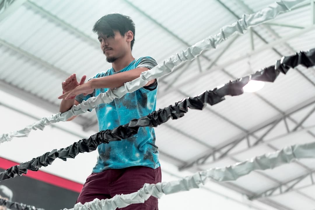 man standing beside boxing ring ropes