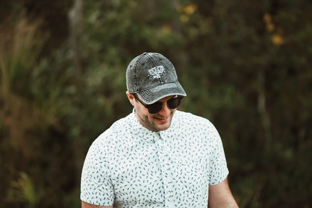 man in white and black polka dot shirt and gray cap