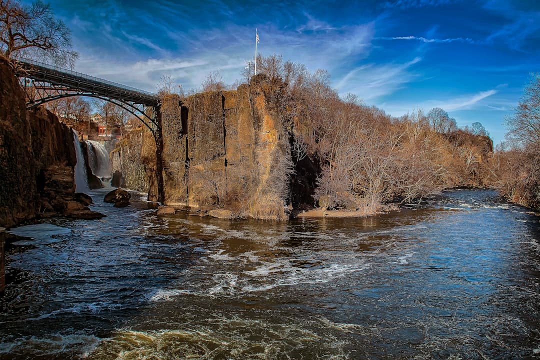 brown concrete building near river under blue sky during daytime