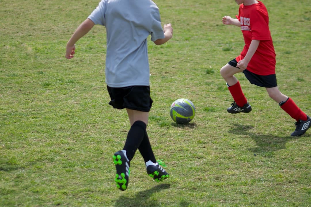 woman in white shirt and black shorts playing soccer