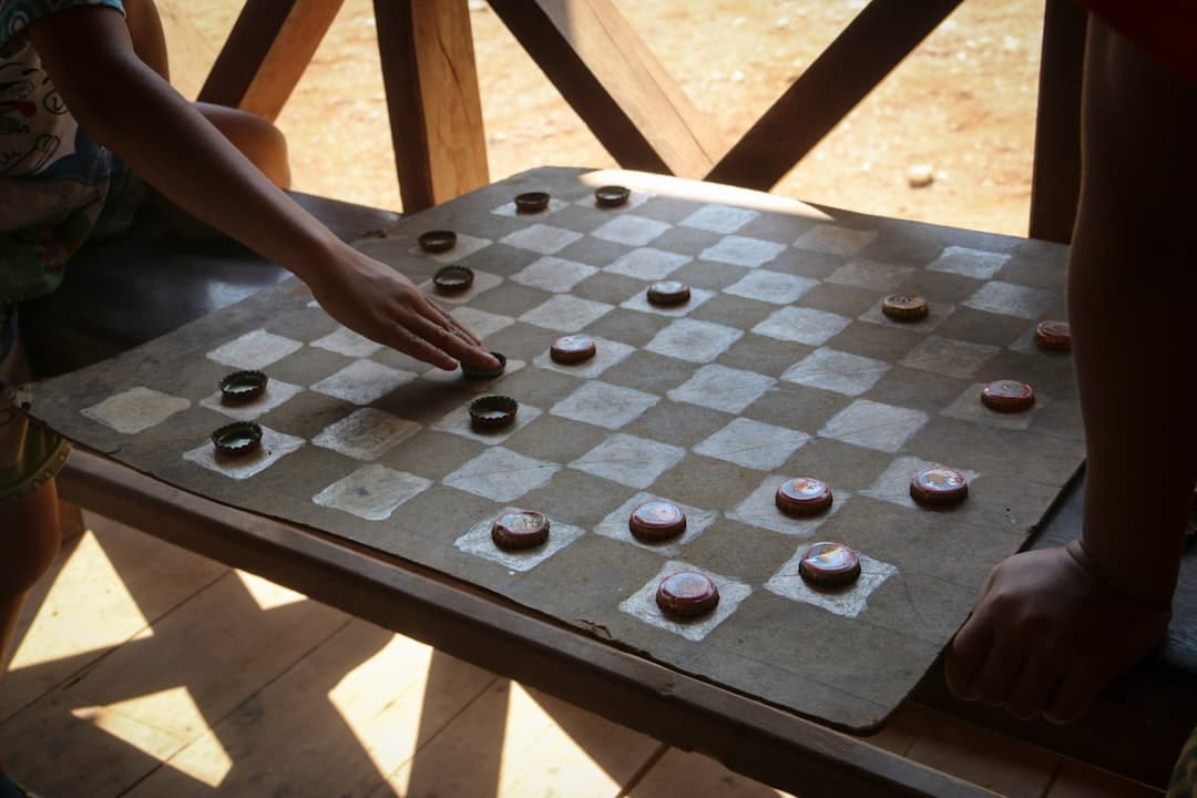 person holding black and white chess board game
