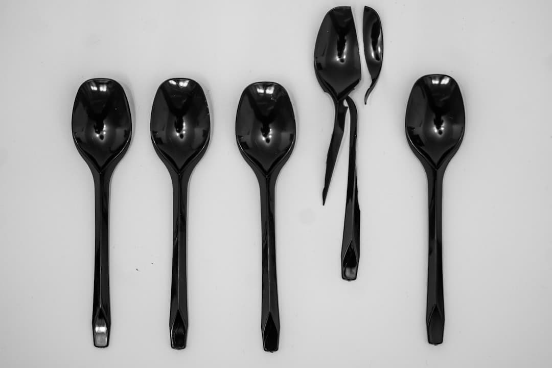 black spoon and fork on white surface