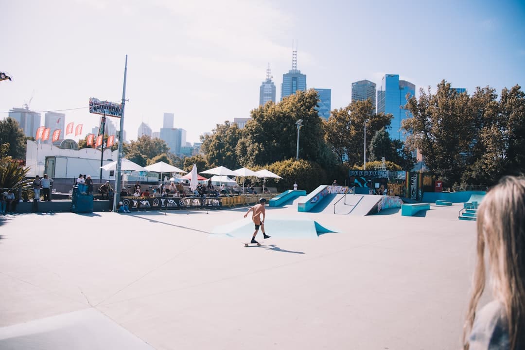 man in black shorts and black shirt doing skateboard stunts on white sand during daytime