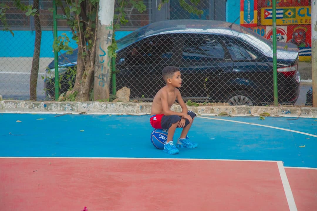 topless man in red shorts playing basketball