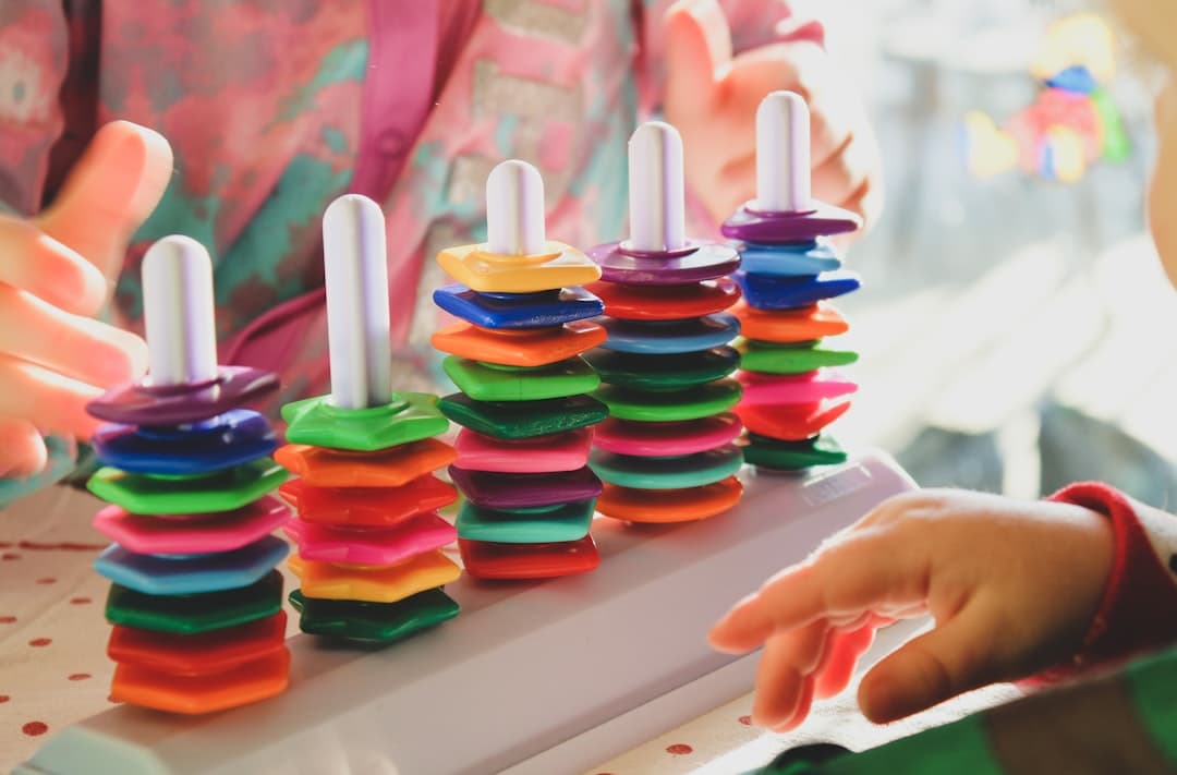 person holding multi colored plastic toy