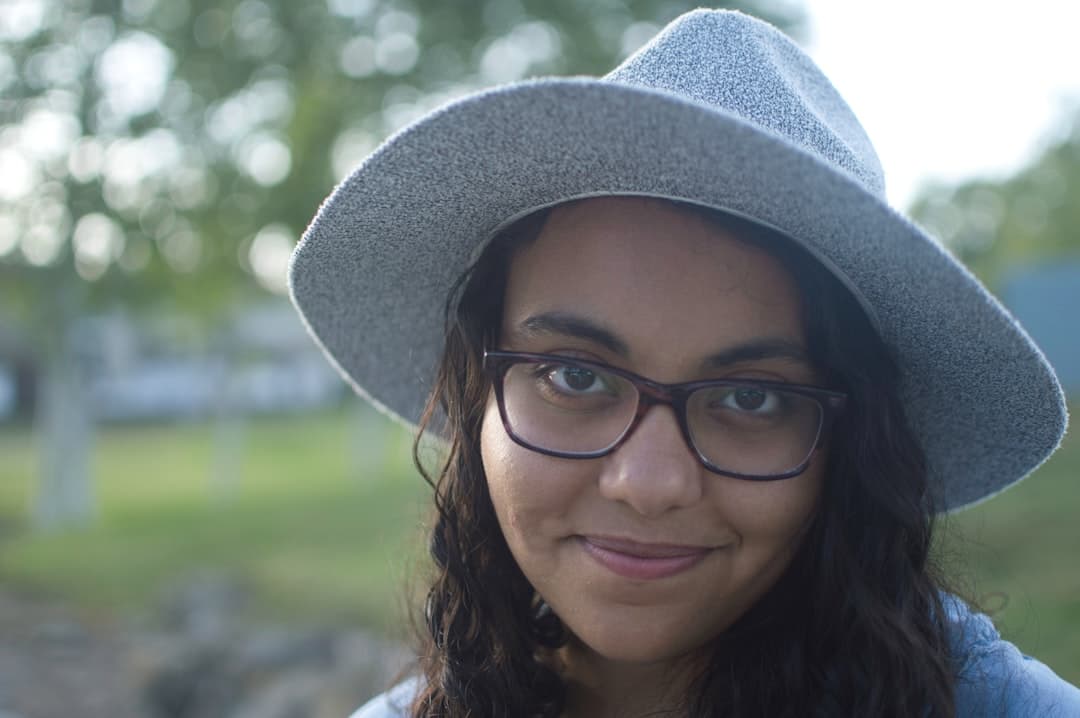 woman wearing gray hat and black framed eyeglasses