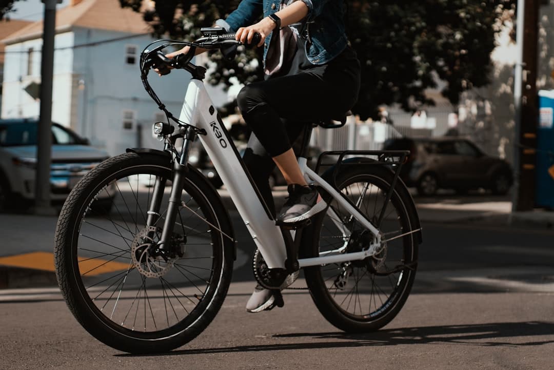 man in black jacket riding on white and black bicycle