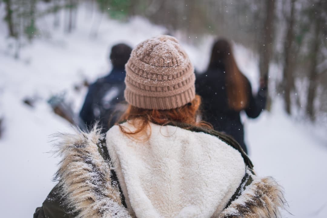 woman in white and brown fur coat wearing brown knit cap