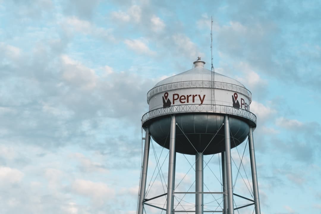 white steel water tank under white clouds during daytime