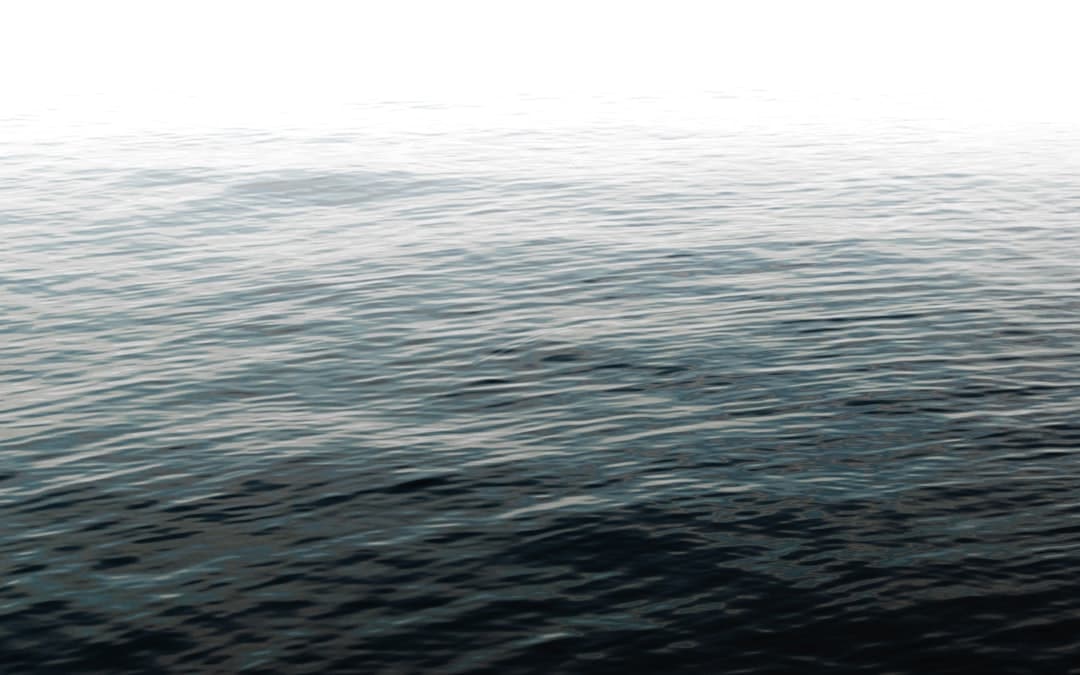 a large body of water with a boat in the distance