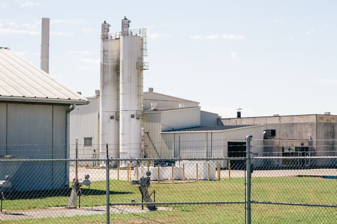 a factory building with a fence surrounding it