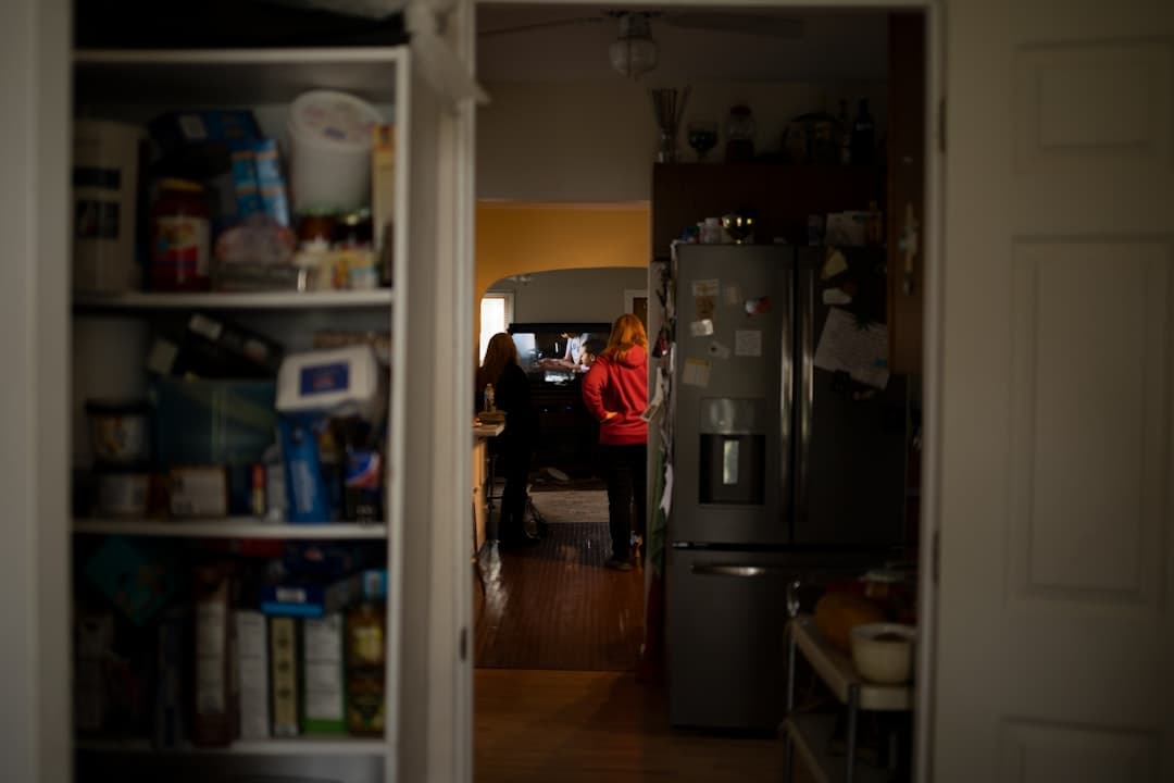 a woman standing in a kitchen next to a refrigerator