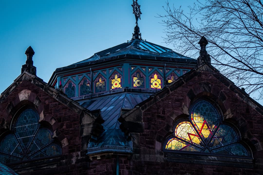 a church steeple with stained glass windows and a cross on top