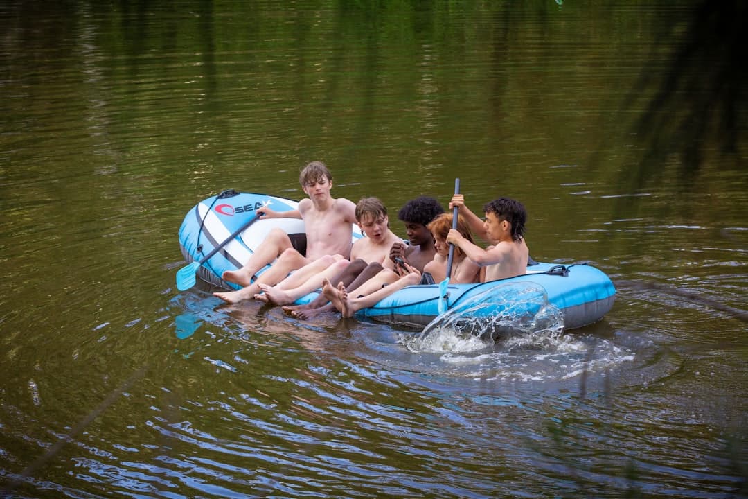 a group of people riding on top of a raft in a body of water