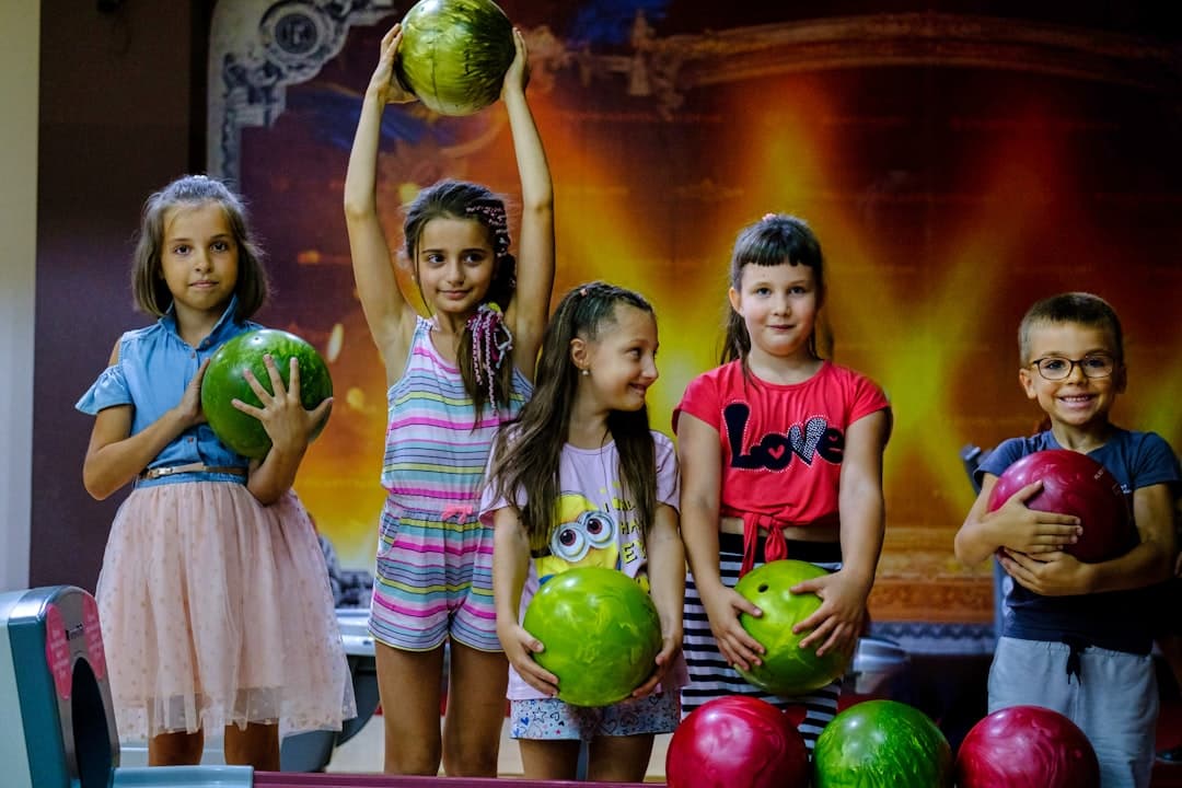 a group of children holding up bowling balls