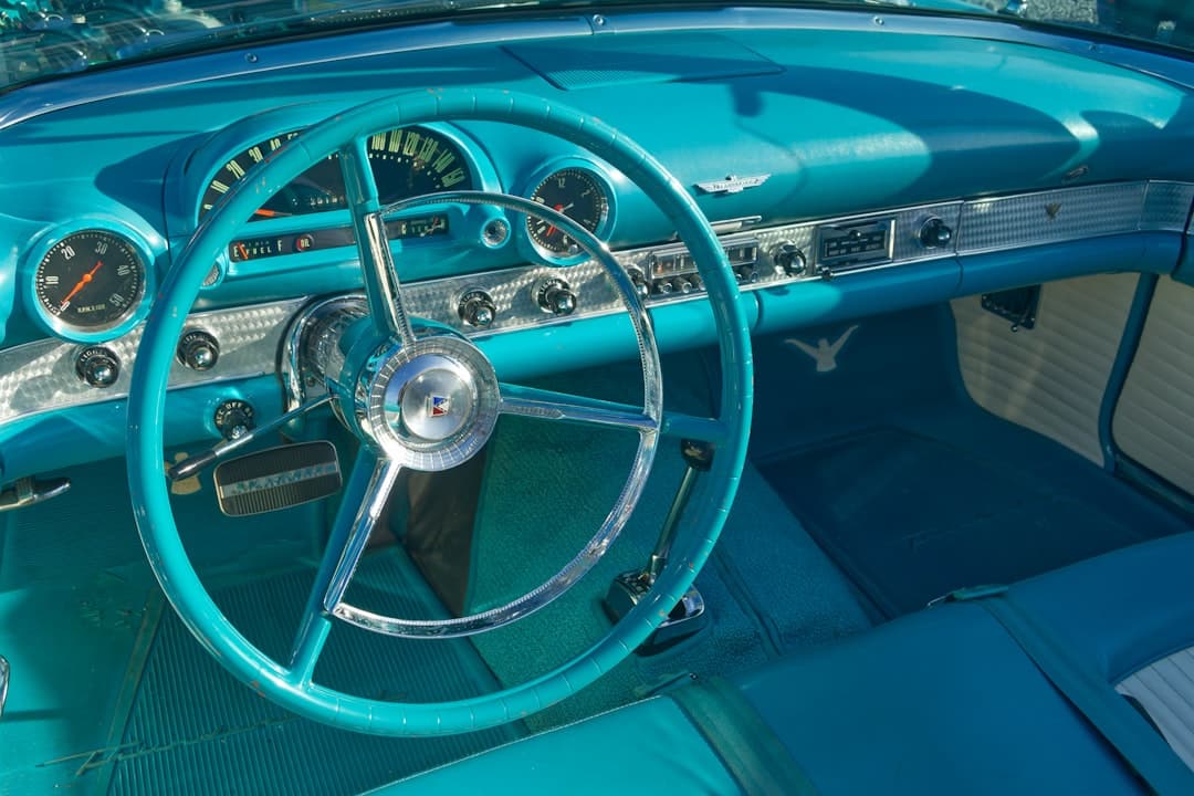 the interior of a blue car with a steering wheel
