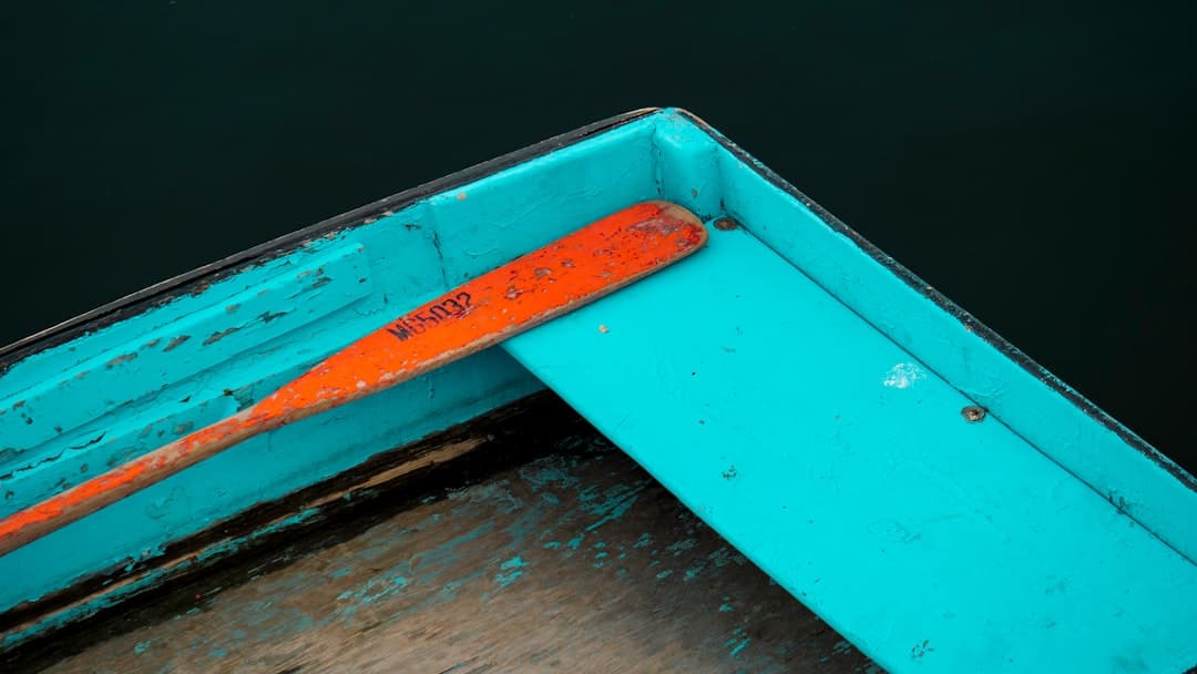 a blue boat with a rusted orange handle