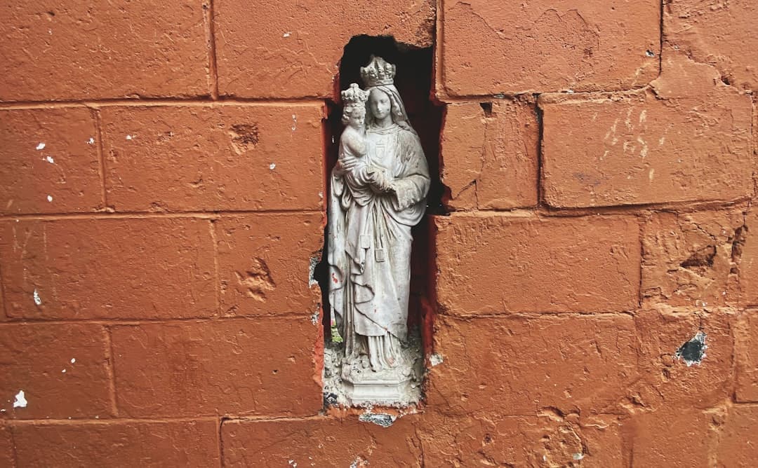 a statue of a virgin mary on a brick wall