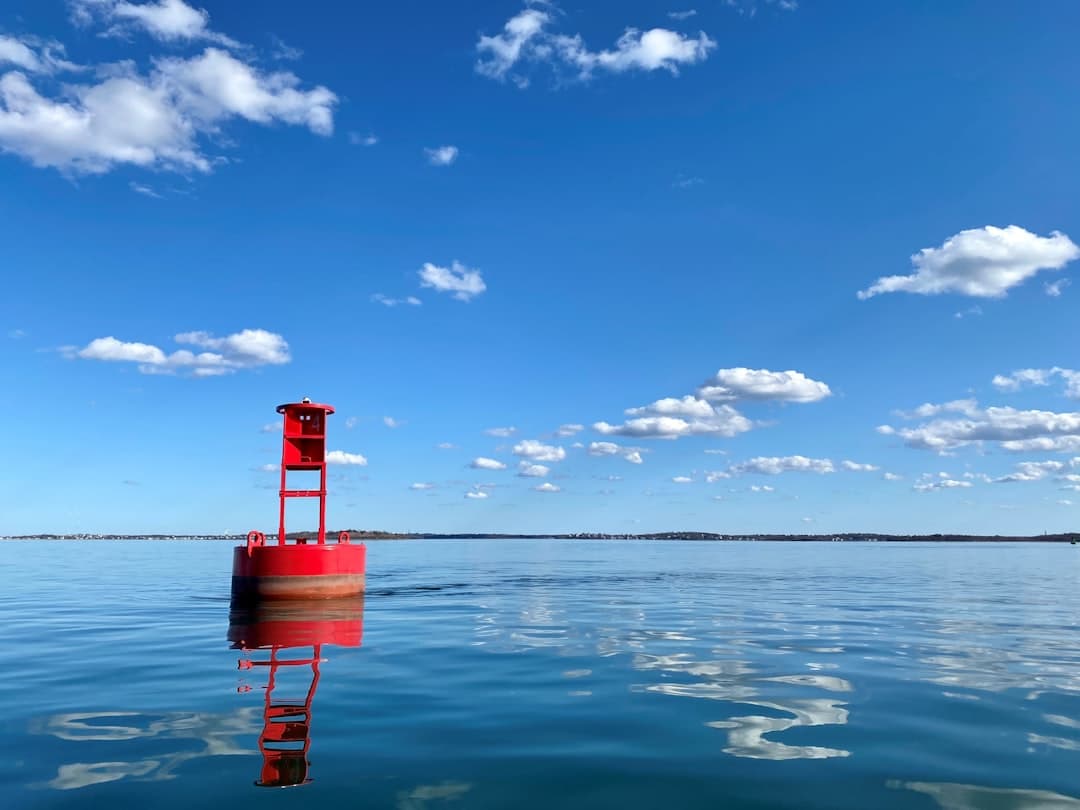 a red tower in the middle of a body of water