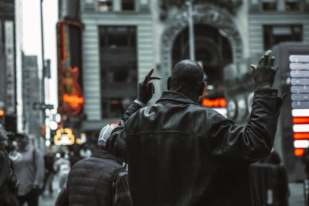 a person in a black coat holding the hands up