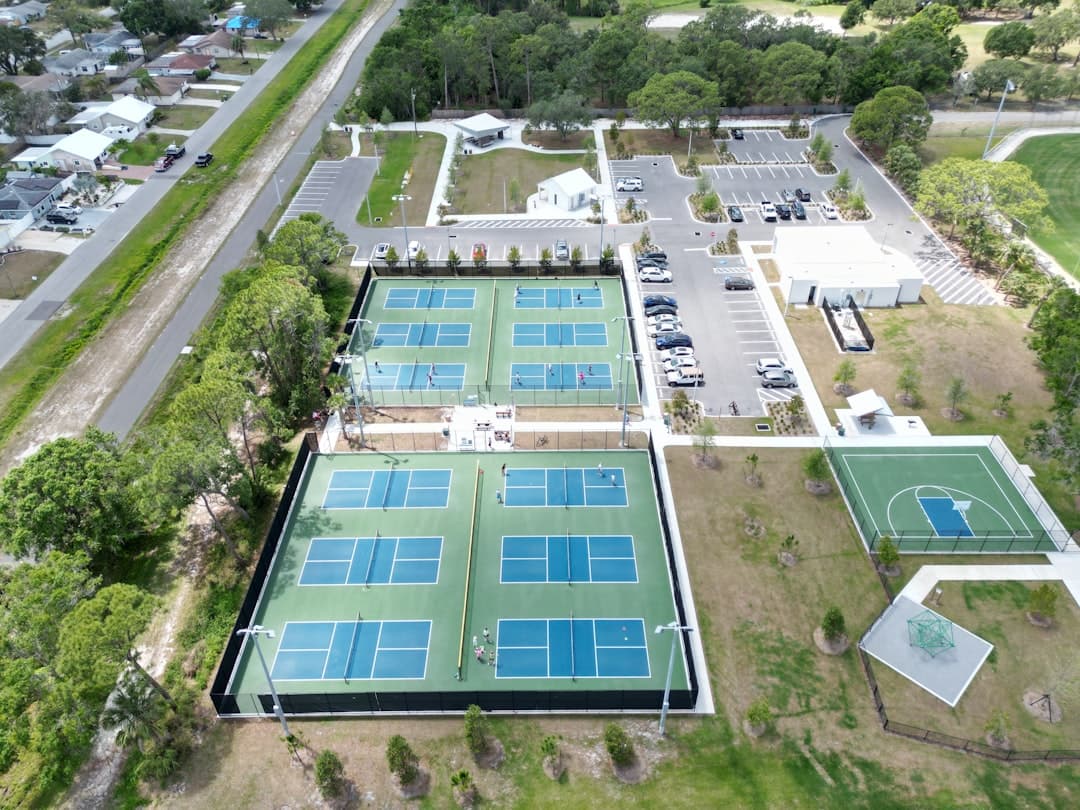 an aerial view of a tennis court and parking lot