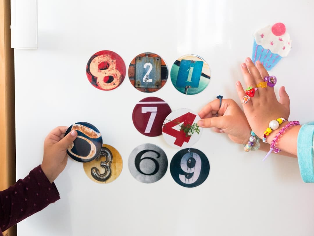 two children are playing with magnets on a refrigerator