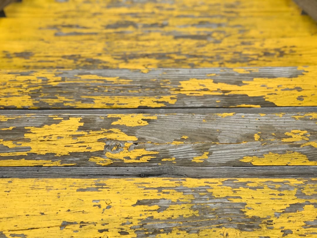 a close up of a yellow painted wooden bench