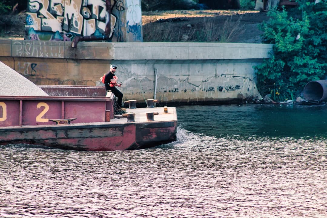 a man riding on the back of a boat in the water