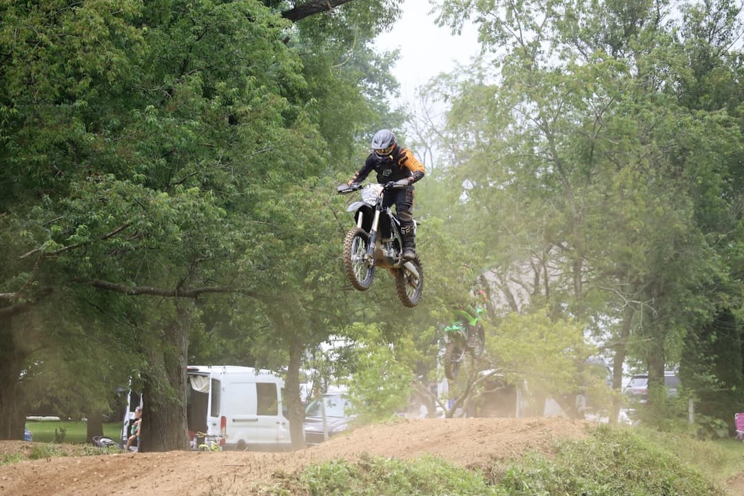 a person on a dirt bike jumping over a hill