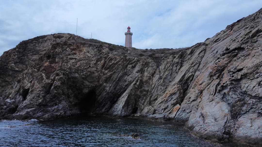 a lighthouse on top of a rocky outcropping