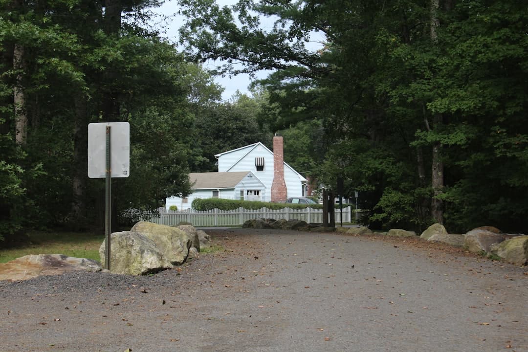 a white house surrounded by trees and rocks