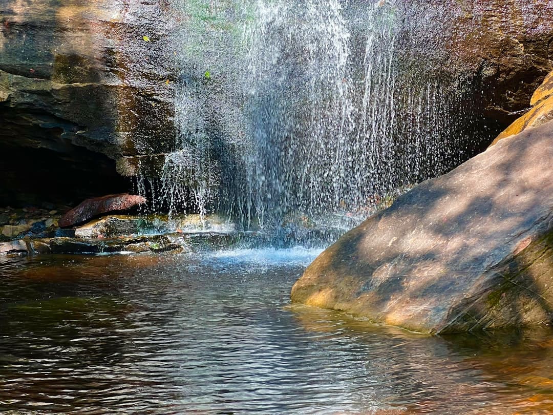 a waterfall is coming out of a cave