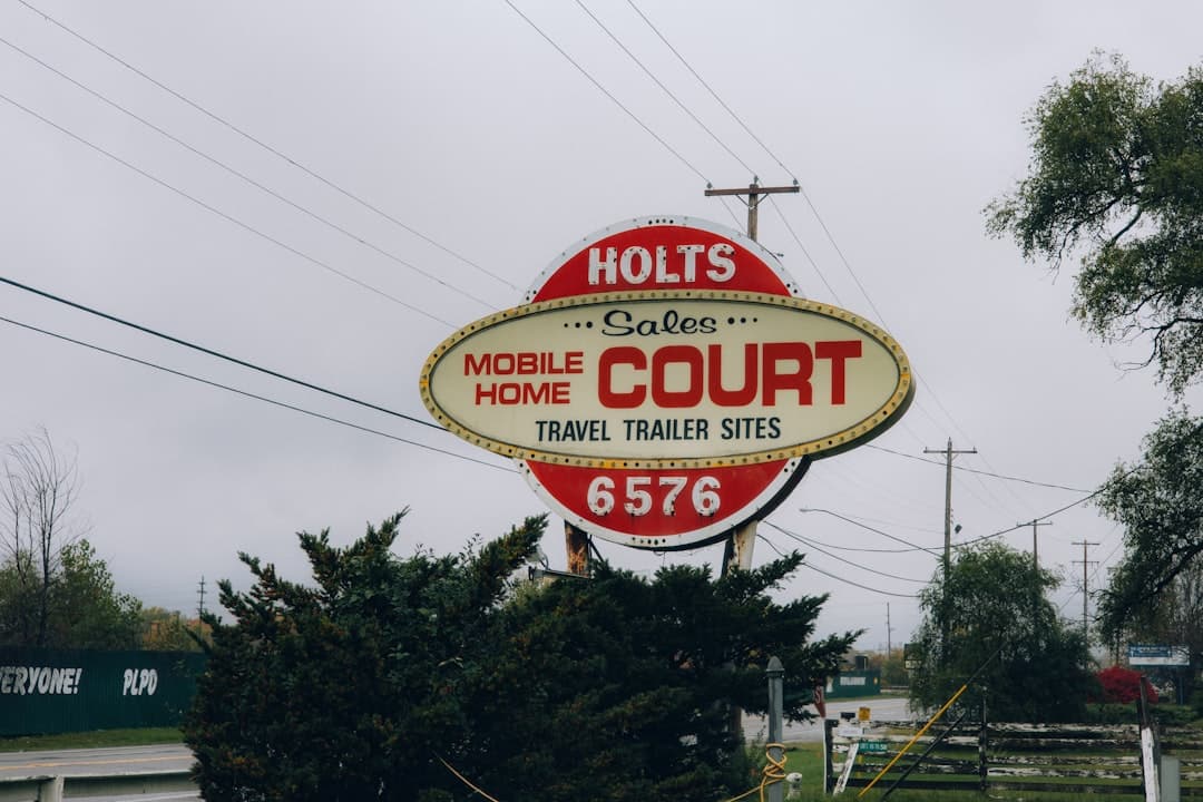 a sign for a mobile home court sits on the side of the road