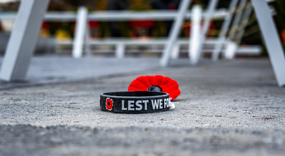 a black wristband with a red poppy on it